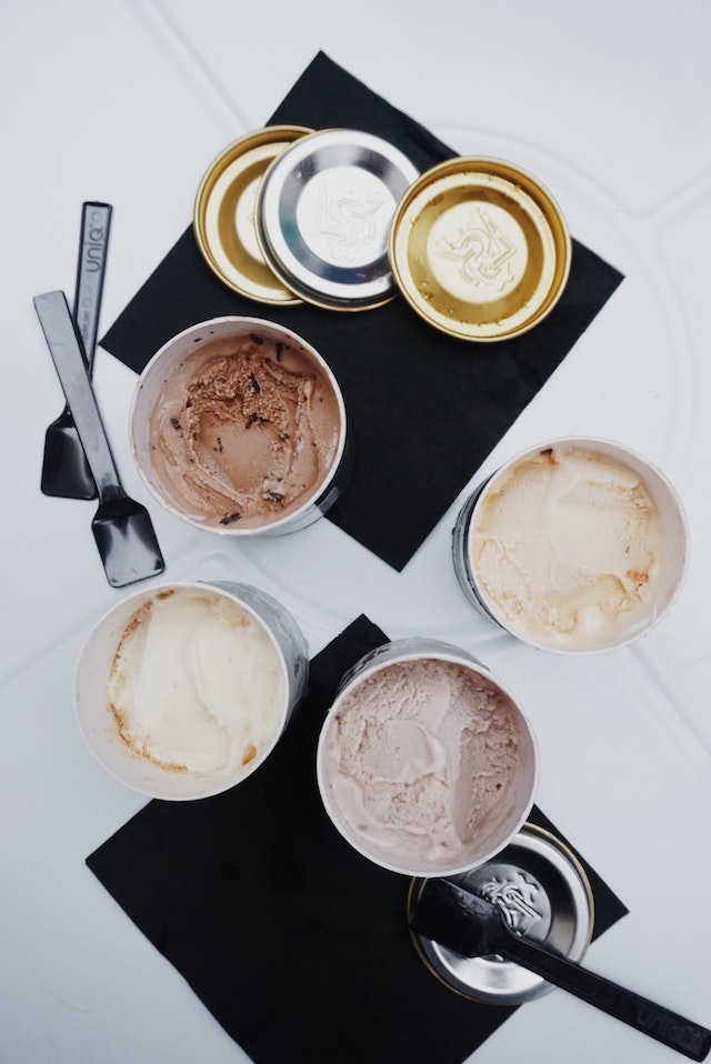 various pints of ice cream on black napkins